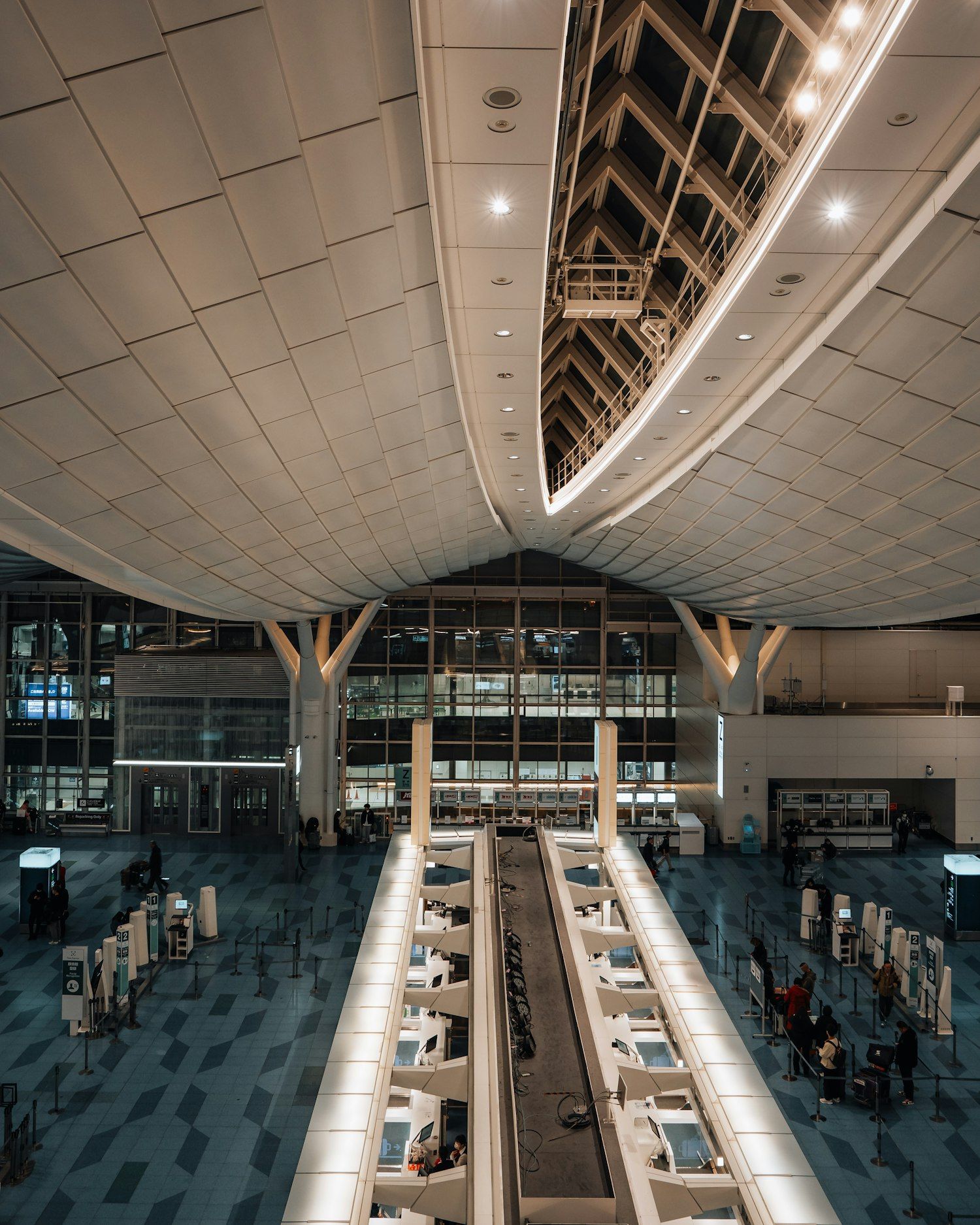 Verrière d’un terminal d’aéroport, éclairée le soir.