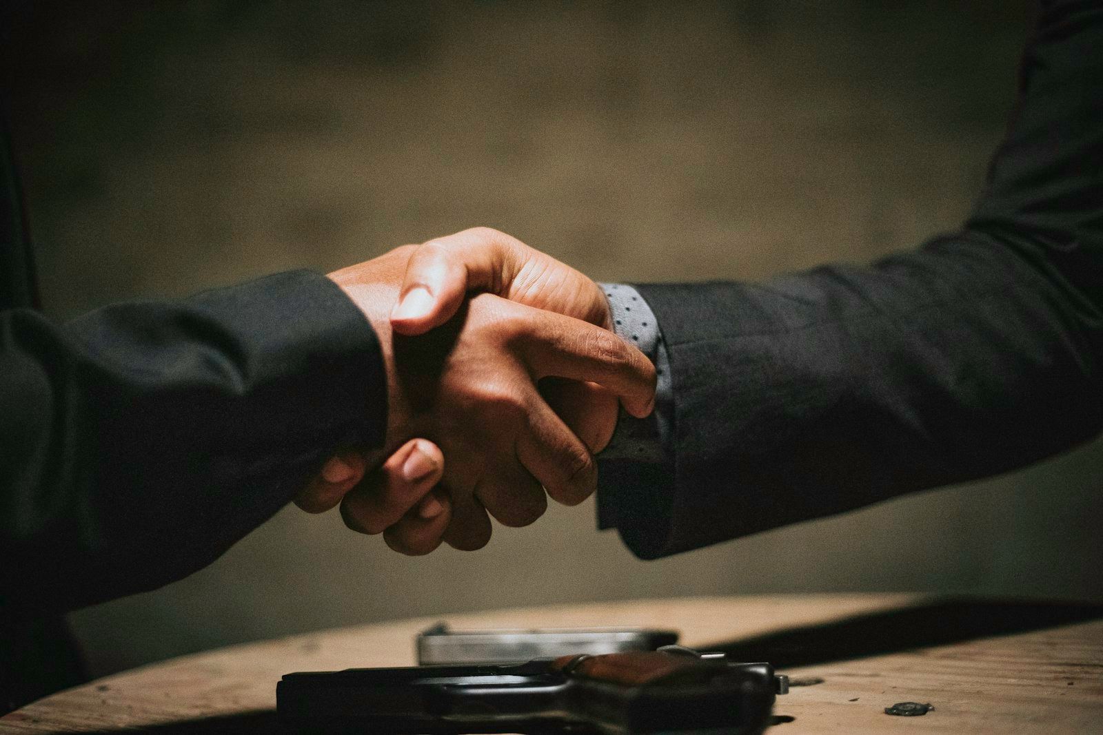 Poignée de main entre deux personnes en costume, en gros plan.